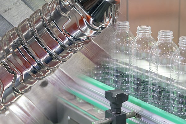 Blow molded plastic bottles at a production line